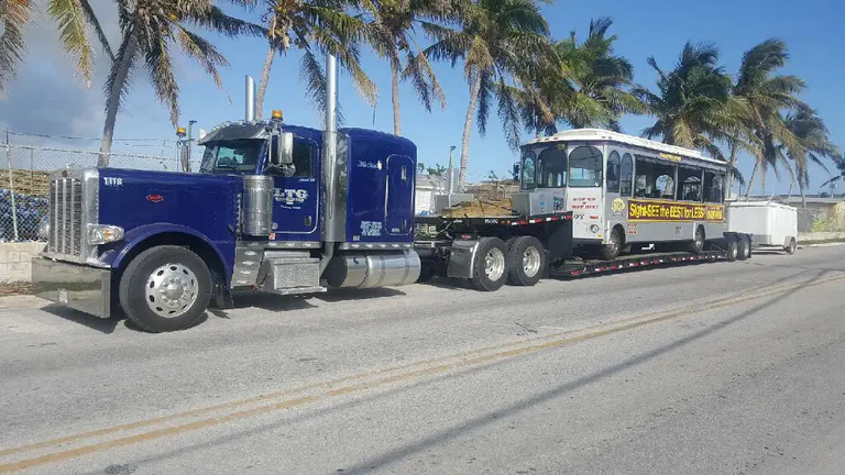 A photograph of a semi truck hauling a streetcar.