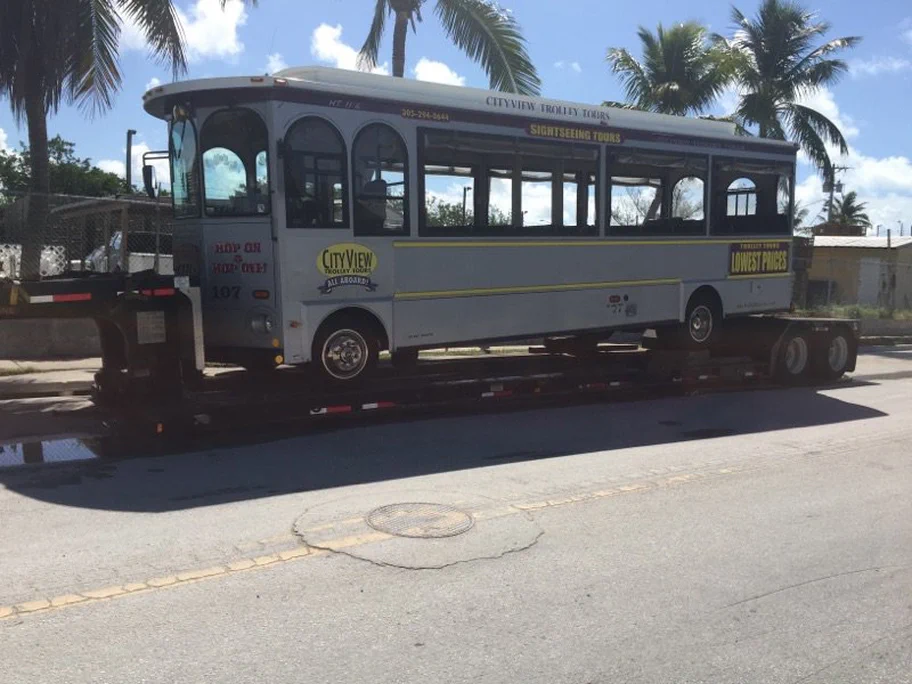 A photograph of a street car being hauled to its final destination.