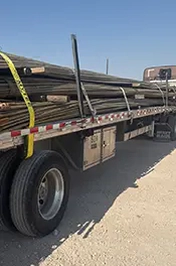 Photo of sucker rods on a flatbed truck.