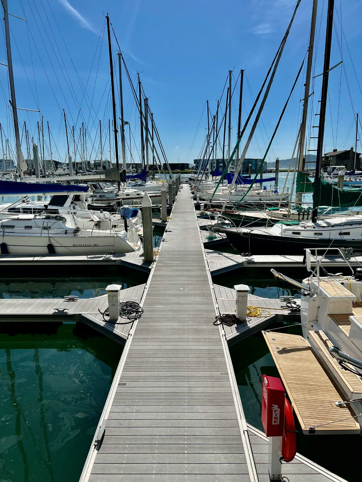 Sailboats docked at a concrete paver boat dock.